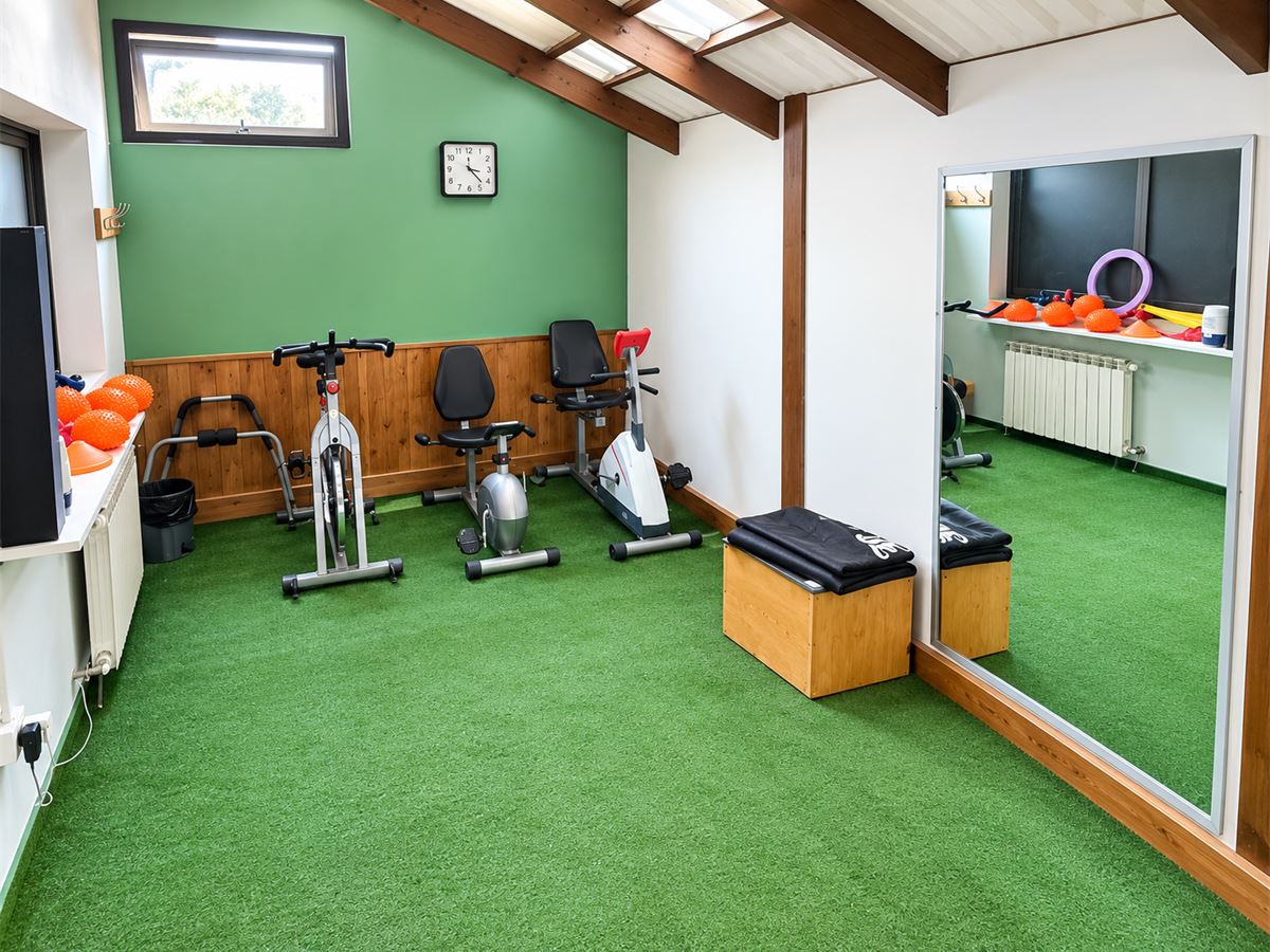 Bicicletas fijas, cajón de salto y espejo grande en el gimnasio